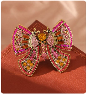 Detailed close-up of a vintage butterfly brooch with pink and orange rhinestones