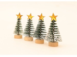 Detailed view of four mini green Christmas trees with gold stars and wooden bases