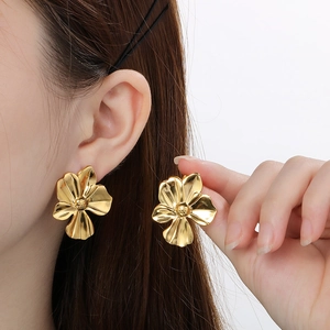 Detailed close-up of golden ginkgo leaf earrings showing intricate petal texture