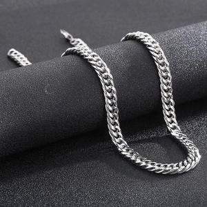 Close-up of polished silver titanium steel curb chain necklace on a dark surface