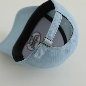 Rear view of light blue denim baseball cap with adjustable bronze metal buckle and logo