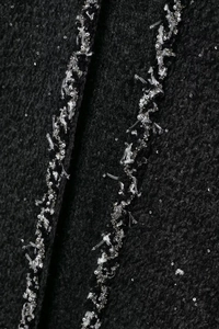 Gros plan sur tissu en tweed noir avec paillettes scintillantes et broderie de perles