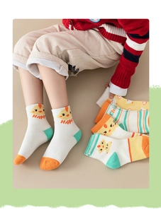 Detail of baby cotton knee-high socks featuring cute cartoon chick patterns and HAPPY text