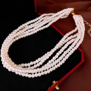 Collier élégant à plusieurs rangs de perles blanches avec fermoir doré sur soie