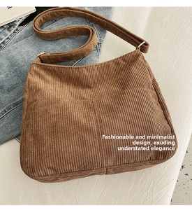 Detail of brown corduroy crossbody bag texture and adjustable strap with gold metal buckle
