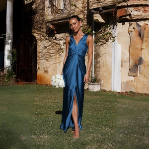 Détail de robe de soirée en satin bleu avec décolleté en V profond et fente élégante
