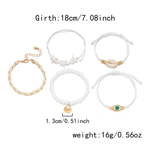 Detail view of 5-piece multi-layer pearl bracelet set with starfish and evil eye charms