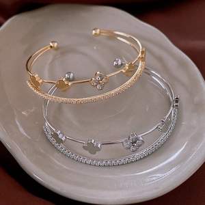 Close-up of double-layered clover bracelets with cubic zirconia in gold and silver finish