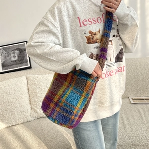 Detail shot of a soft plush shoulder bag featuring colorful checkered plaid wool material