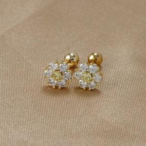 Macro detail of daisy stud earrings with yellow and white zircons on champagne satin