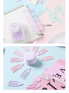 Vue macro de trombones en plastique en forme de U aux couleurs Macaron avec boîte de rangement