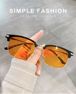 Close-up of retro orange lens sunglasses with black half-frame and silver metal accents