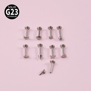 G23 titanium labret studs set with heart star and moon shapes on pink background