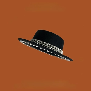 Vista detallada del sombrero de fieltro de lana negro con elegantes perlas y borde perlado