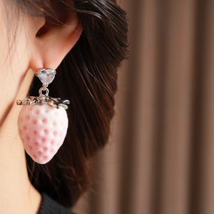 Detail of pink strawberry drop earrings with silver leaf and heart-shaped rhinestone stud