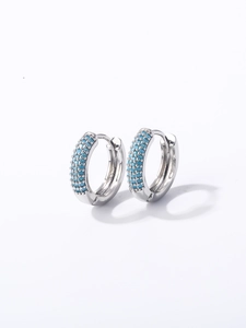 Détail macro de créoles en argent S925 avec trois rangées de petites perles turquoise