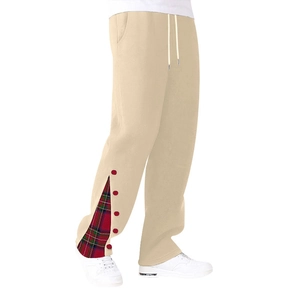 Dettaglio dei pantaloni in cotone beige con patchwork a quadri rossi e bottoni