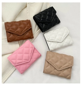 Detailed flat lay of quilted leather mini bags in brown, black, white, pink, and khaki