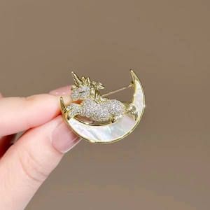 Unicorn and crescent moon gold-tone alloy brooch featuring rhinestones and mother of pearl