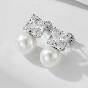Macro shot of S925 silver stud earrings featuring square zircon and white pearl details