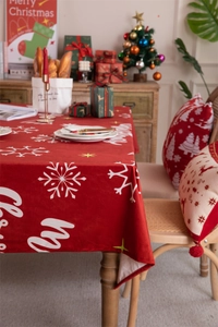 Close-up of red Christmas tablecloth featuring white snowflakes in a cozy holiday setting