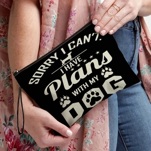 Black canvas makeup bag with dog slogan print and wristlet strap held by a model