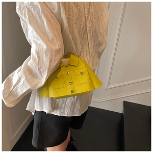 Detail of creative suit-style lemon yellow crossbody bag with metal buttons and chain