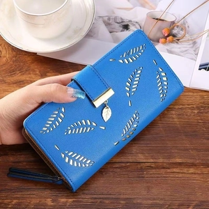 Detail of royal blue leather wallet with hollow leaf cutouts and gold pendant