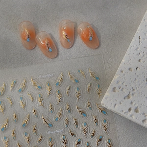 5D bronzing nail stickers featuring gold-edged blue feathers for artistic manicure decor