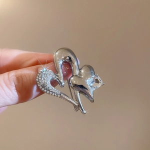 Detailed view of silver double heart brooch with sparkling crystals held in hand