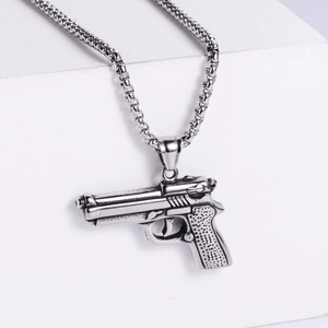 Close-up of retro silver stainless steel pistol pendant with detailed metal texture