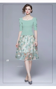 Detail of green square neck knit top with puff sleeves and embroidered A-line skirt