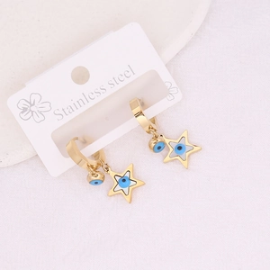 Golden stainless steel star earrings featuring evil eye charms on a white display card
