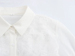 Dettaglio dell'elegante colletto in pizzo bianco con trama a rete ed etichetta taglia S