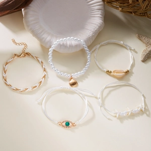 Detail view of five bohemian pearl bracelets with starfish charms and gold accents