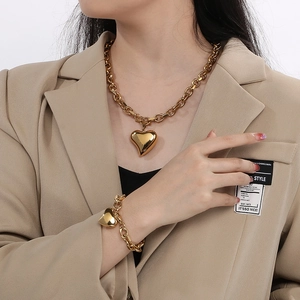 Goldenes Herzanhänger Halsketten und Armband Set aus Titanstahl an einem Model