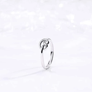Macro shot of silver titanium steel knot ring featuring a polished mirror surface finish