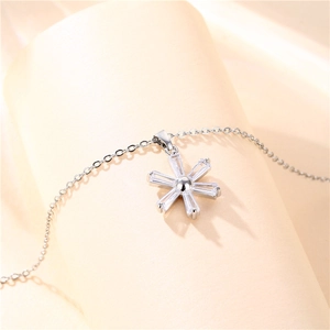 Silver snowflake necklace with clear zircon pendant on light pink display stand