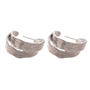 Silver C-shape hoop earrings featuring a unique textured crumpled metal finish on white background