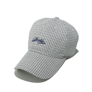 Detailed view of British plaid baseball cap featuring blue script embroidery and fine stitching
