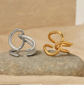 Polished gold and silver geometric open rings displayed on a natural stone surface