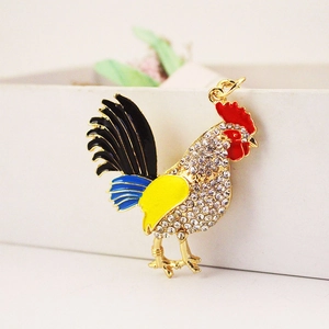 Colorful rooster keychain with enamel finish and crystals on a jewelry box edge
