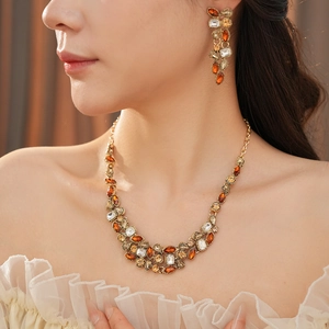 Close-up of model wearing a vintage gold statement necklace and amber teardrop earrings