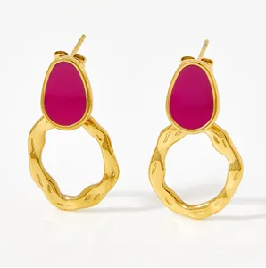 Detail of vintage gold earrings featuring rose red enamel inlay and hammered gold rings