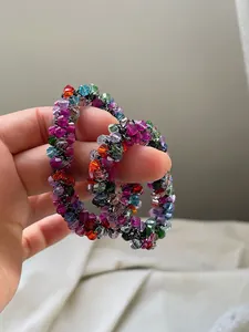 Close-up of colorful crystal beaded hair ties held in hand showing texture and elastic design