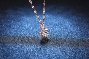 Macro shot of rose gold six-prong moissanite pendant on a fine necklace chain