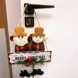 Detail of Santa and Snowman fabric dolls on a Merry Christmas wooden hanging sign