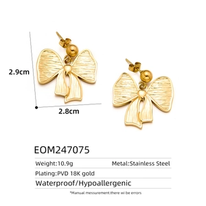 Macro detail of gold bow earrings featuring PVD 18K gold plating and ridged textures