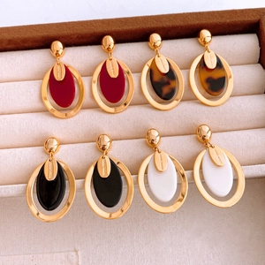 Vue macro de boucles d'oreilles ovales en résine en quatre couleurs sur un plateau