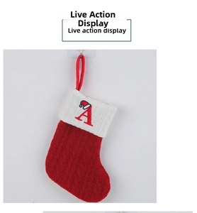 Close-up of red knitted Christmas stocking with white cuff and embroidered letter A